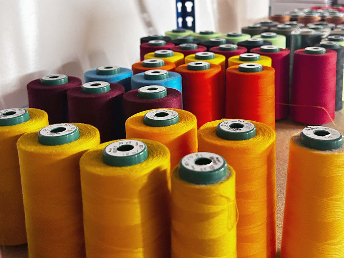 Nahaufnahme von Nähgarn in vielen verschiedenen Farben, organisiert auf einem Regal