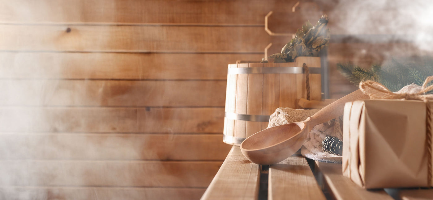 dampfende Sauna mit Sauna Kelle und Kübel natürlich verpacktes Geschenk im Eck