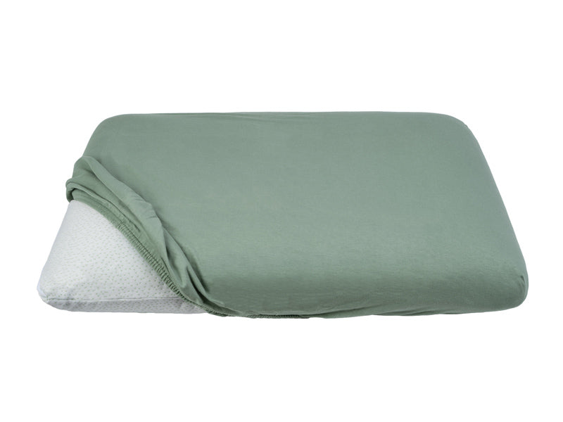 Teilweise bezogenes Kopfkissen mit einem gruenen Kopfkissen-Spannbezug auf einem weissen Hintergrund.