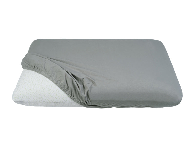 Teilweise bezogenes Kopfkissen mit einem grauen Kopfkissen-Spannbezug auf einem weissen Hintergrund.