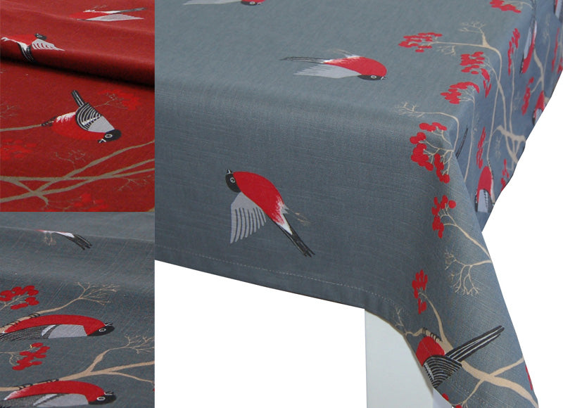 Ecke einer grauen Tischdecke, bedruckt mit rot-grau-schwarzen Voegeln. Teilweise fliegend und teilweise sitzen Sie auf Zweigen mit roten Beeren. Daneben ein Ausschnitt einer roten Tischdecke mit dem gleichen Motiv.