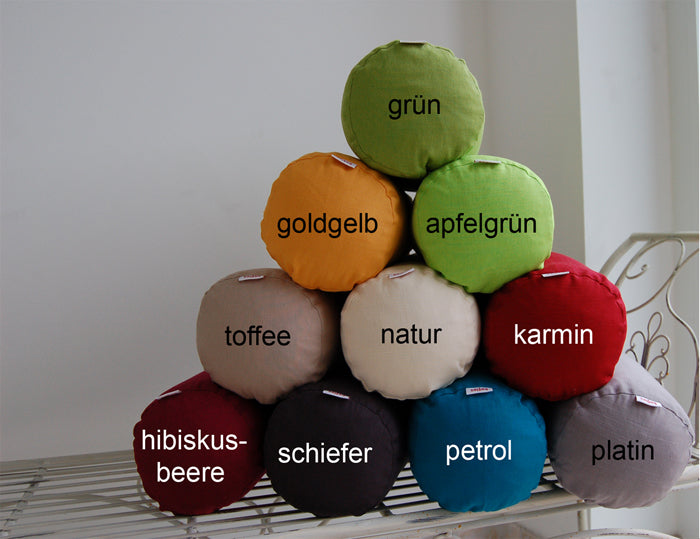 Nackenrollen als Pyramide gestapelt. Bezogen mit einfarbigen Kissenbezuegen in den Farben Hibiskus-Beere, Schiefer-Grau, Petrol, Platin-Grau, Toffee, Natur-Beige, Karmin-Rot, Gold-Gelb, Apfel-Gruen und Gruen.