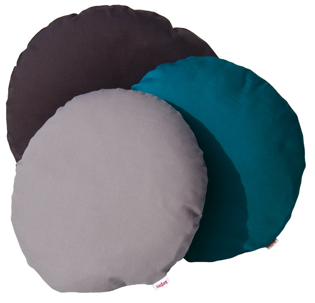 Drei einfarbige, runde Kissen in den Farben Schiefer-Grau, Hellgrau und Petrol auf einem weissen Hintergrund.