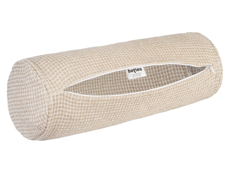 Eine Nackenrolle mit einem Bezug aus beigem Waffelpique-Stoff mit geöffnetem Reissverschluss.