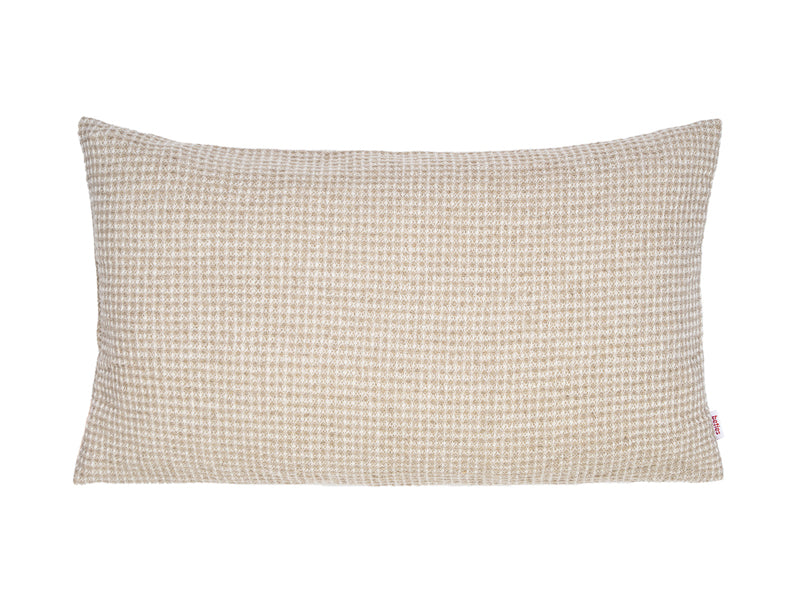 Ein rechteckiges Kissen mit einem Bezug aus beigem Waffelpique-Stoff.