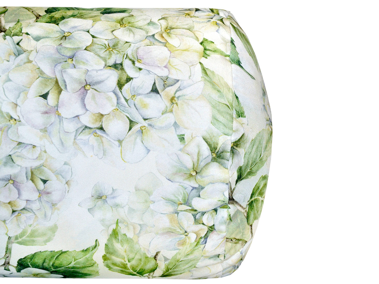 Nahaufnahme eines Kissenbezugs für Kissen in Rollenform im Landhausstil, bedruckt mit weissen Hortensien-Blueten.