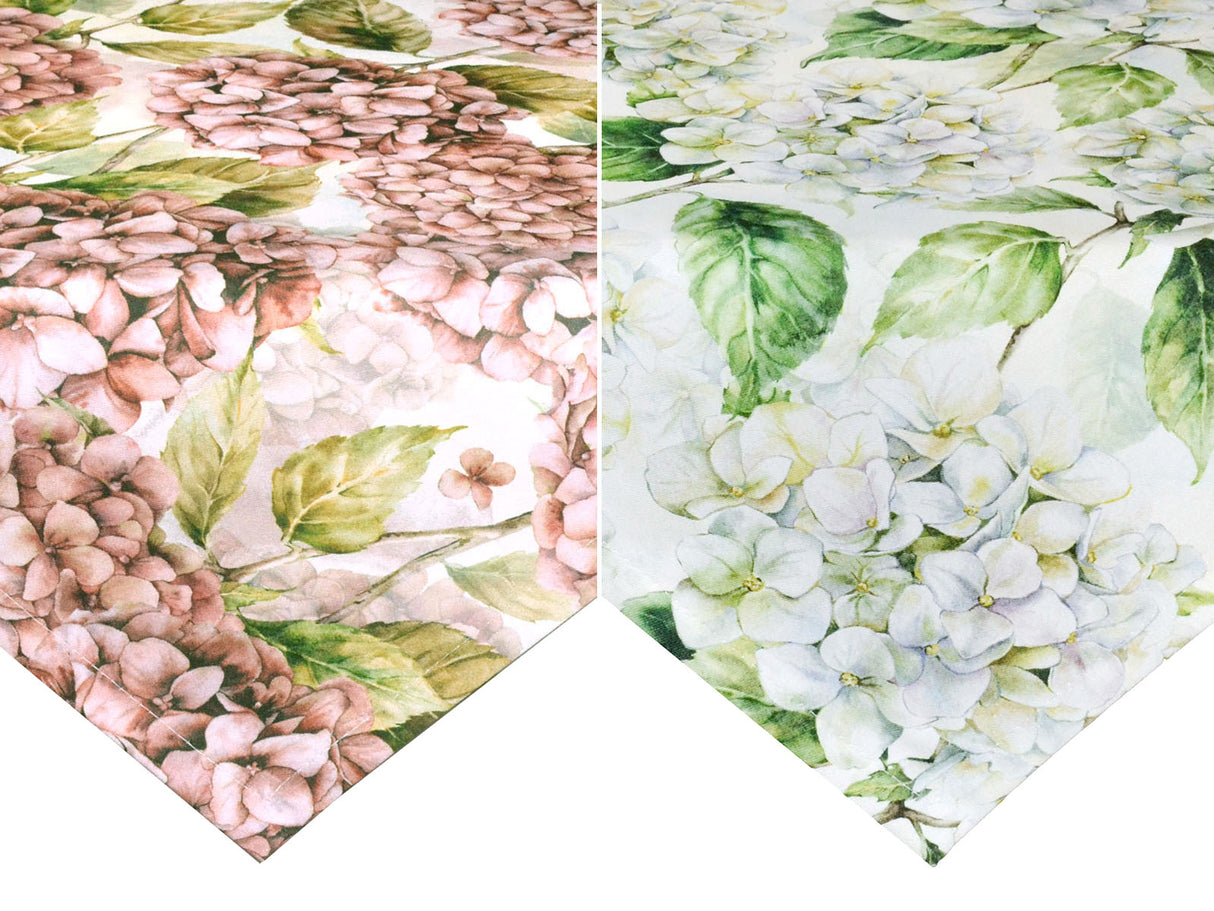 Zwei helle, geblümte Mitteldecken, einer mit rosa/pinken und einer mit weissen Hortensienblueten.