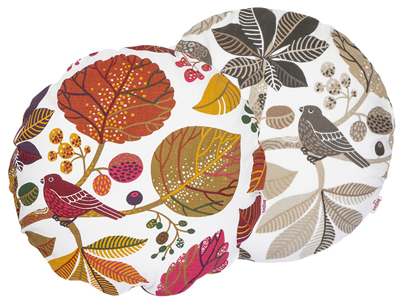 Zwei runde Kissenbezuege mit Blaetter, Zweigen und Voegeln auf weissem Hintergrund bedruckt. Einer ist in den Farben braun/taupe und der andere ist ganz bunt gehalten.