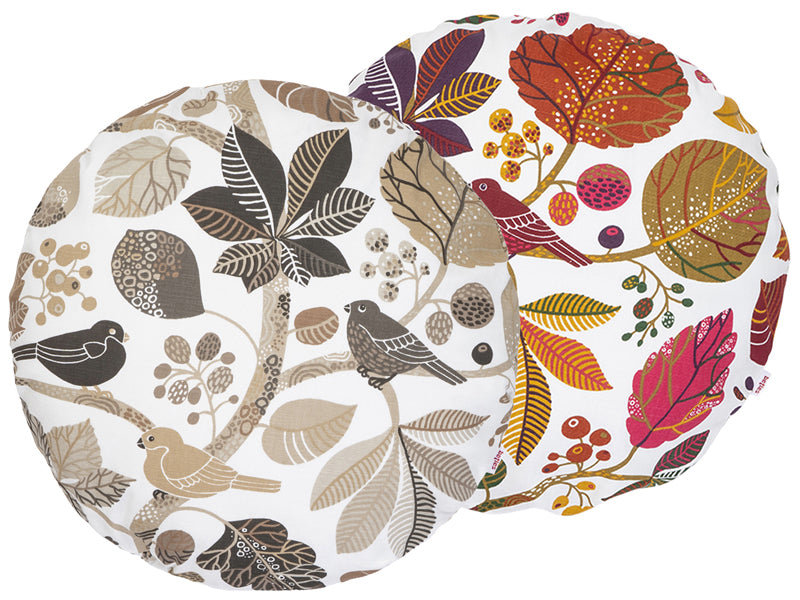 Zwei runde Kissenbezuege mit Blaetter, Zweigen und Voegeln auf weissem Hintergrund bedruckt. Einer ist in den Farben braun/taupe und der andere ist ganz bunt gehalten.