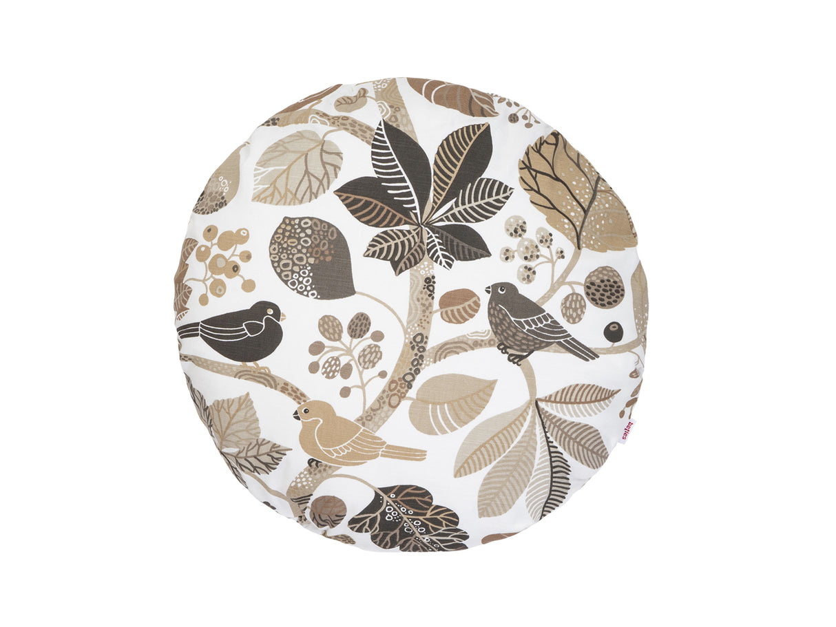 Ein runder Kissenbezug mit braunen und taupe Farbenen Blaettern und Zweigen auf weissem Hintergrund.