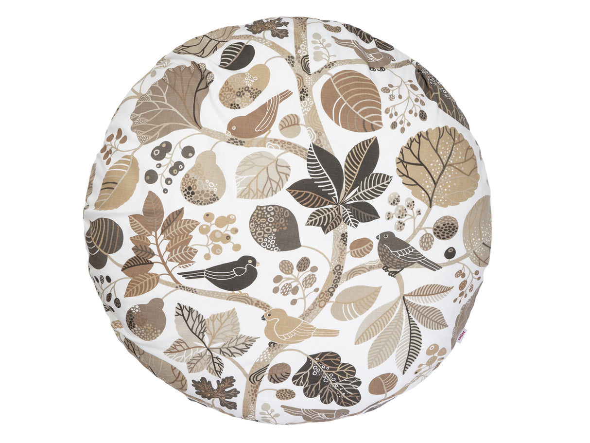 Ein runder Kissenbezug mit braunen und taupe Farbenen Blaettern und Zweigen auf weissem Hintergrund.