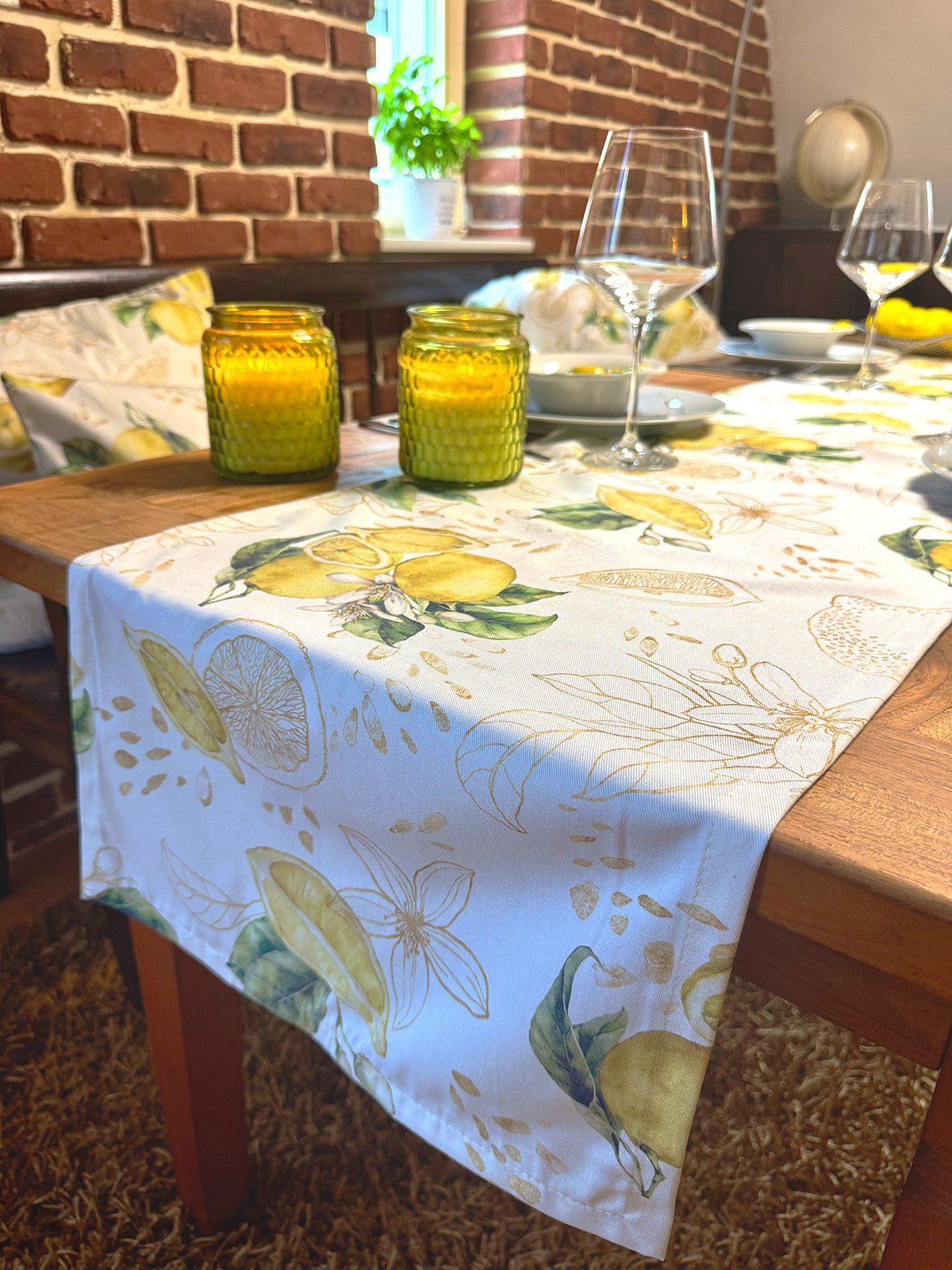 Hellbeiger Tischläufer mit Zitronenmuster und goldenen Akzenten, flach liegend.