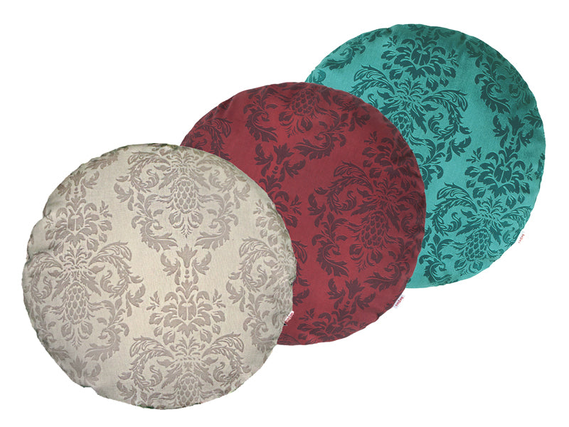 Drei runde Kissen hintereinander, bezogen mit Kissenbezuegen in den Farben Beige, Rot und Petrol. Bedruckt sind die Bezuege mit barocken Ornamenten in der jeweiligen Farbe, nur etwas dunkler.