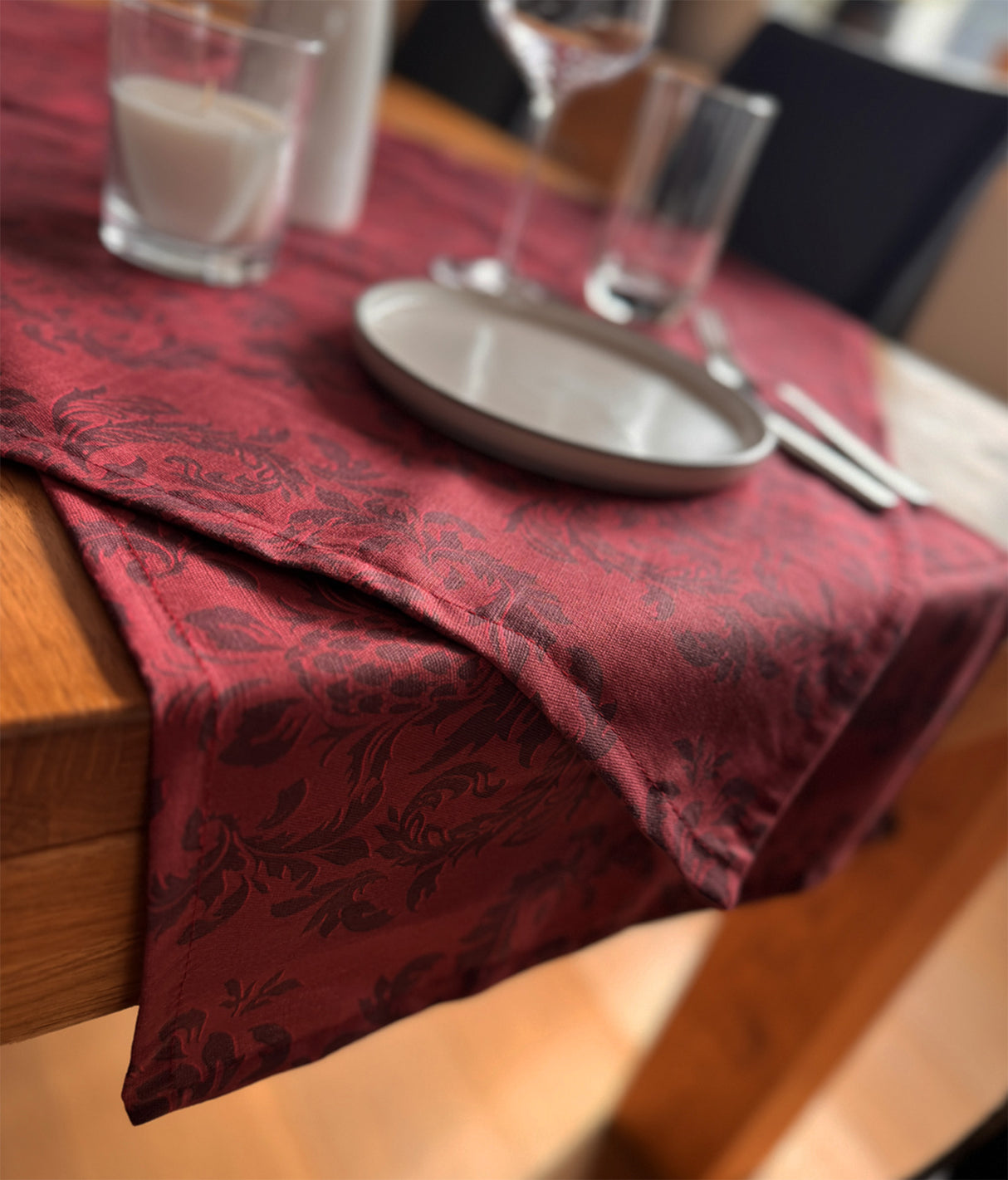 Roter Tischlaeufer, bedruckt mit barocken Ornamenten in einem dunkleren Rot.