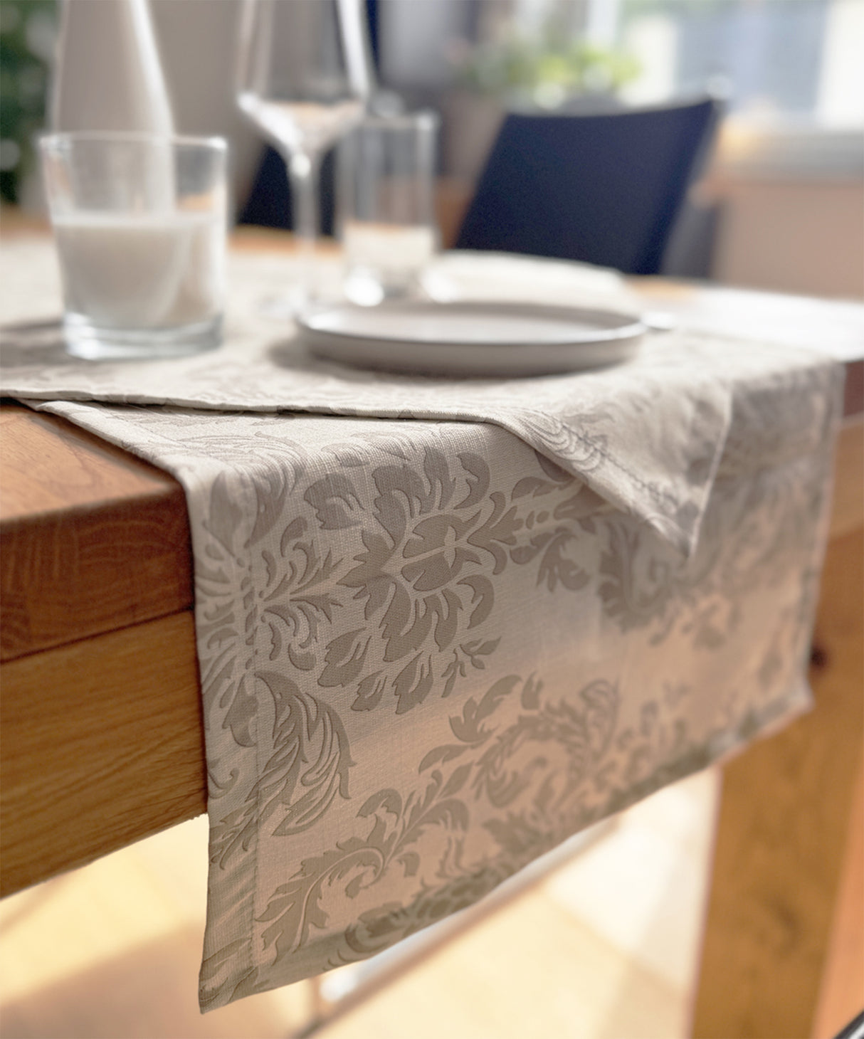 Beiger Tischlaeufer, bedruckt mit barocken Ornamenten in einem dunkleren beige.
