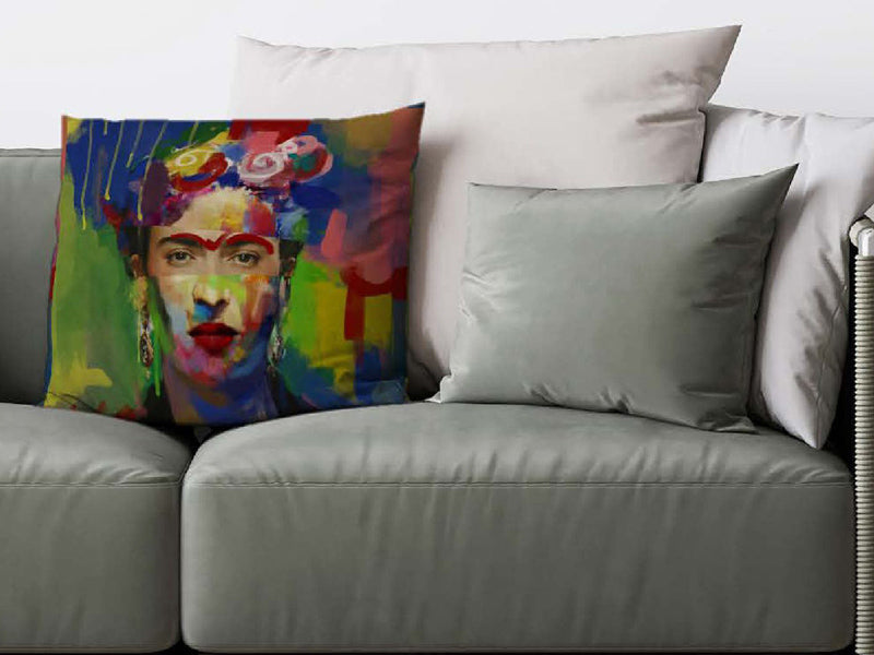 Auf einem grauen Sofa ist ein bunter Kissenbezug mit dem Portrait einer beruehmten mexikanischen Kuenstlerin dekoriert.