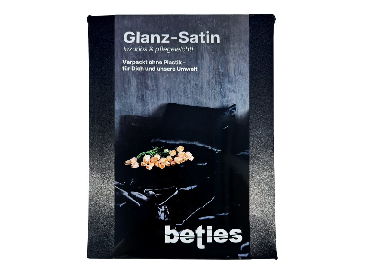 Schwarzes Glanz Satin Spannbetttuch. Verpackt mit einer edlen, schwarzen Karton-Banderole.