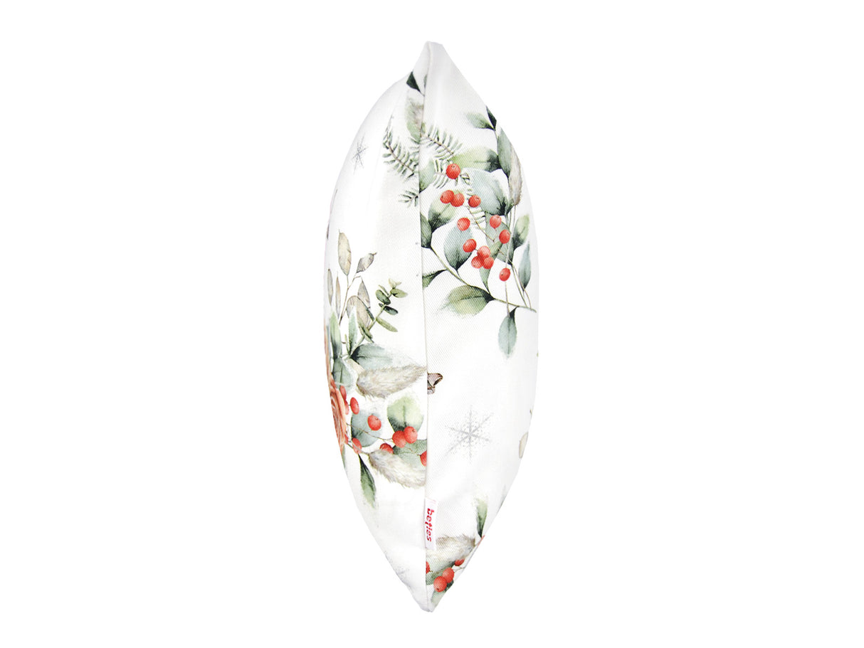 Weisse Kissenhuelle ca. 30x50 cm – Winterdeko mit orangen, gefrosteten Rosen, Kieferzapfen und Zweigen im Alloverdruck. Ansicht von der Seite mit dem beties Label – 100% Baumwolle – Aus der beties Magie des Winters "Frost-Rose" Kollektion.