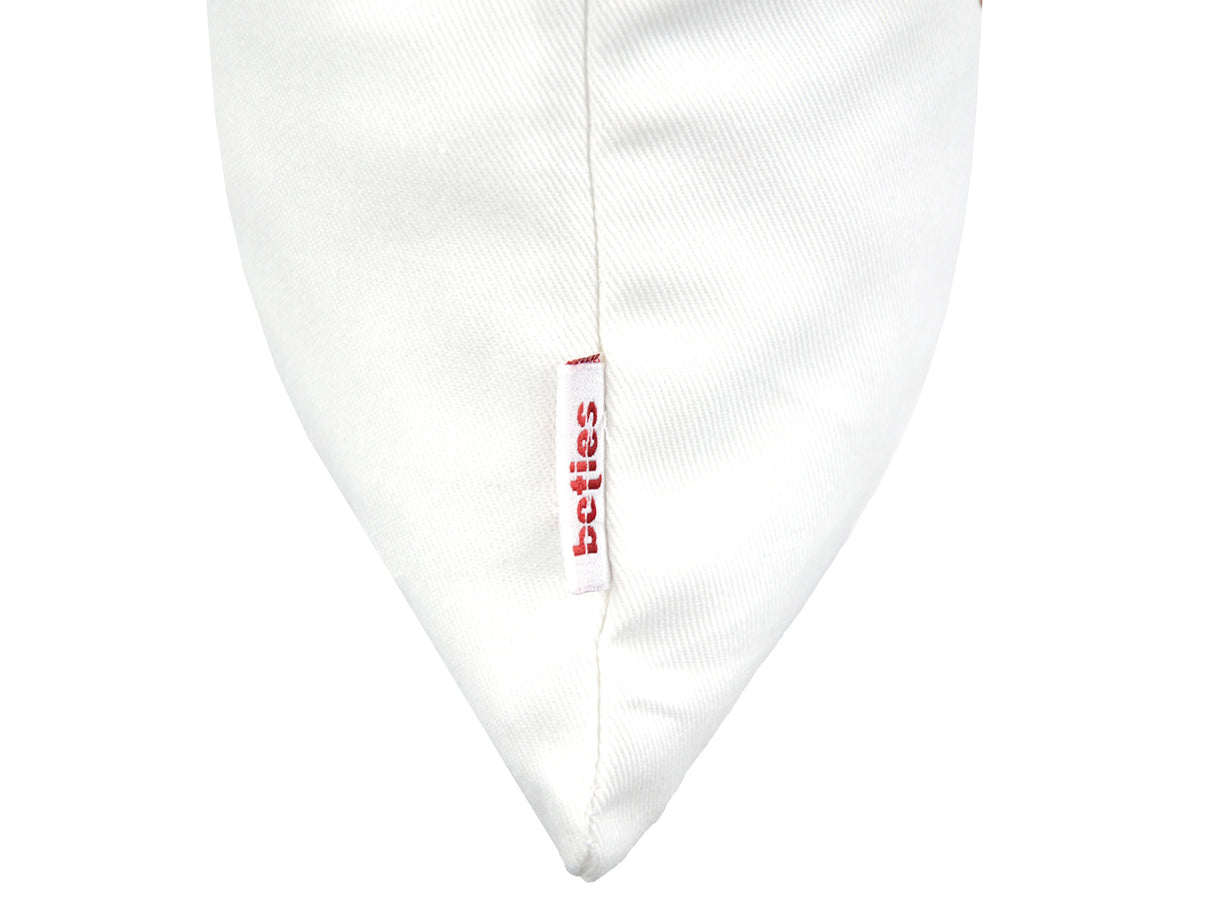 Weisse Kissenhuelle ca. 25x35 cm – Winterdeko mit orangen, gefrosteten Rosen, Kieferzapfen und Zweigen. Detailansicht des beties Label – 100% Baumwolle – Aus der beties Magie des Winters "Frost-Rose" Kollektion.