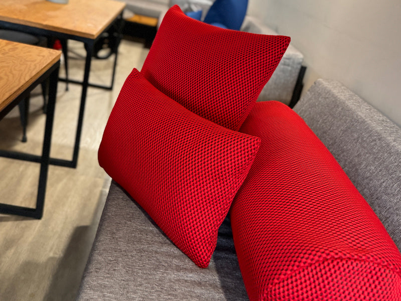 Rote 3D-Waben-Design Kissenbezuege sind auf einem Sofa dekoriert.