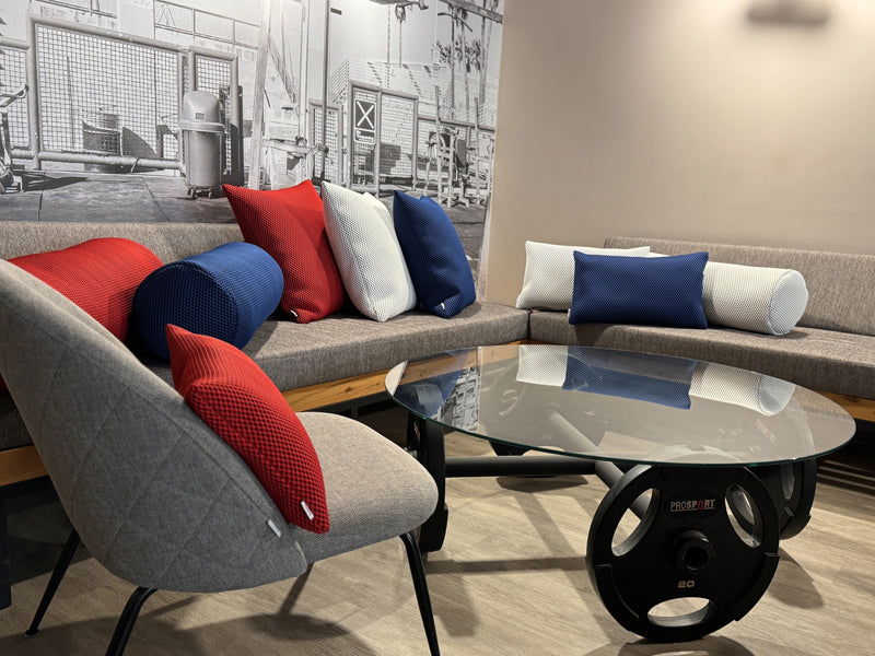 Kissenbezuege im 3D-Waben-Design in den Farben rot, weiss und blau sind auf einem Sofa dekoriert.