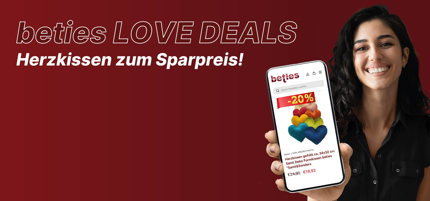 Frau mit Handy in der Hand wie sie Black Week Love Deals im Handy zeigt 20% Rabatt auf Herzkissen