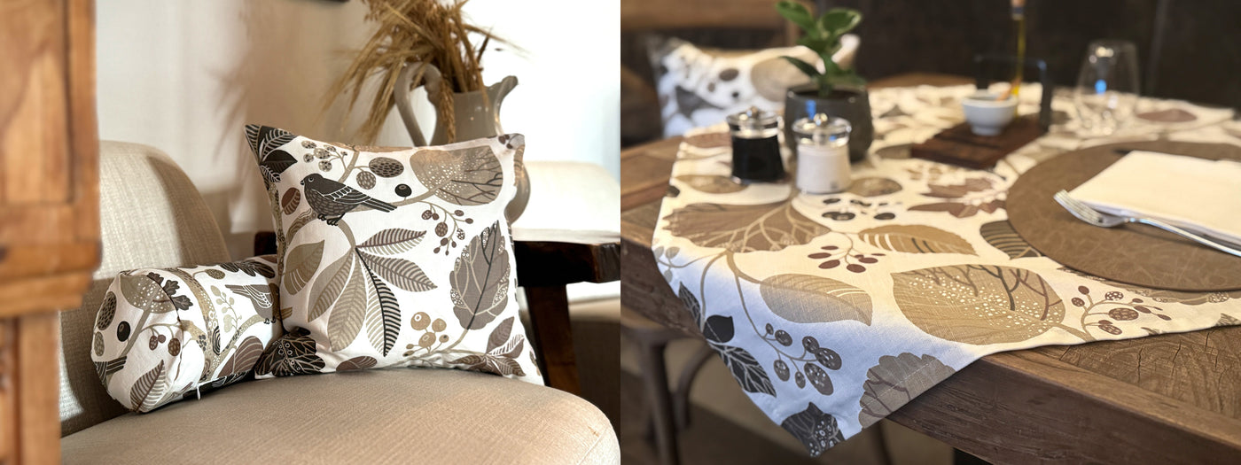 gedeckter Tisch mit Zauberwald taupe Tischdecke und geütlicher Sessel mit Weizenähren im Hintergrund