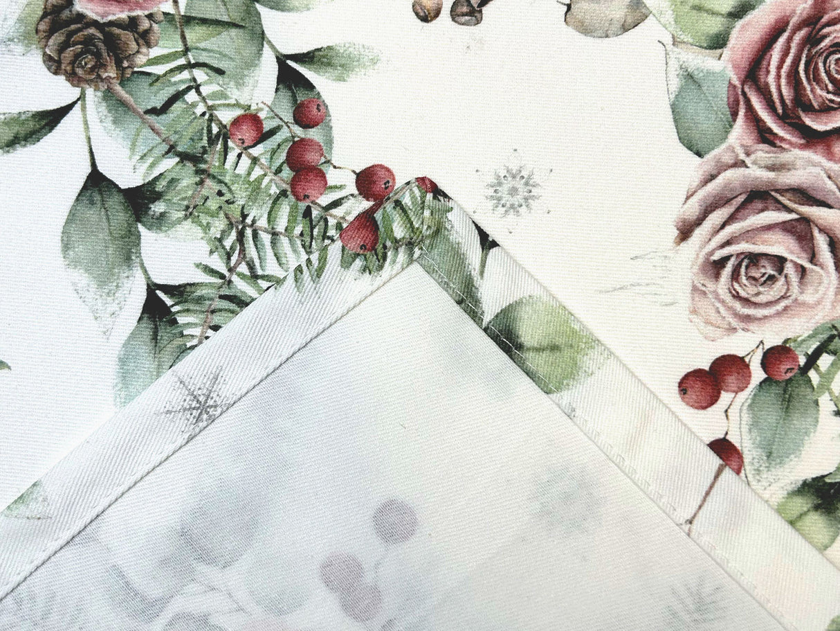 Detailansicht der Kuvertecke einer weissen Tischdecke – Winterdeko mit gefrosteten Rosen in mauve, Kieferzapfen, Beeren und Zweigen – 100% Baumwolle – aus der beties Magie des Winters "Frost-Rose" Kollektion.