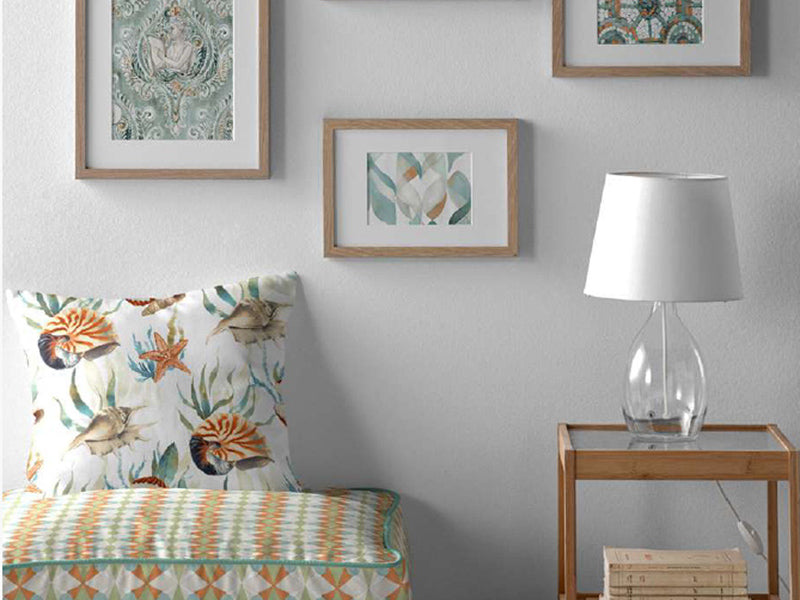 Palettensofa mit darauf drapierten quadratischen Kissen. Dies sind mit verschiedenen Kissenhuellen in Erdfarben bezogen. 