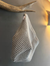 Ein beties Sauna Beanie Saunakappe an einem Haken in einem Saunabereich